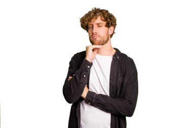 Genç beyaz adam yeşil krom arka planda izole edilmiş şüpheli, belirsiz, seni muayene ediyor..