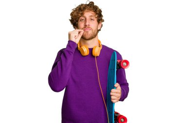 Young skater caucasian man isolated on white background with fingers on lips keeping a secret.