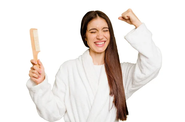 Young Caucasian Woman Holding Hair Comb Isolated Raising Fist Victory — Stock Photo, Image