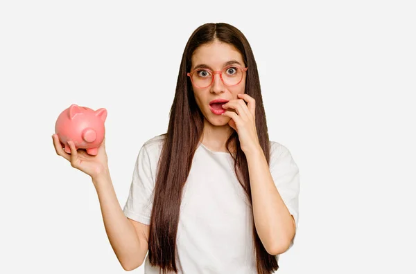 Junge Kaukasische Frau Hält Ein Sparschwein Und Beißt Fingernägel Nervös — Stockfoto