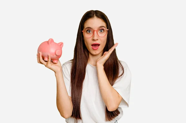 Young Caucasian Woman Holding Piggy Bank Isolated Surprised Shocked — Stock Photo, Image