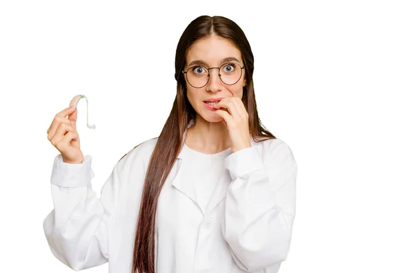 Jonge Otorhinolaryngoloog Blanke Vrouw Met Een Hoortoestel Geïsoleerd Bijtende Vingernagels — Stockfoto