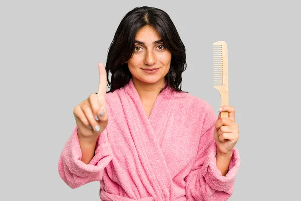Bornozlu Genç Bir Kadın Saç Tarağı Tutuyor Bir Numarayı Parmağıyla — Stok fotoğraf