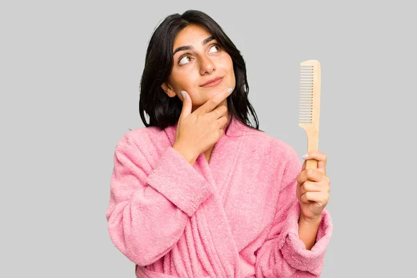 Young Woman Bathrobe Holding Hair Comb Isolated Looking Sideways Doubtful — Stock Photo, Image