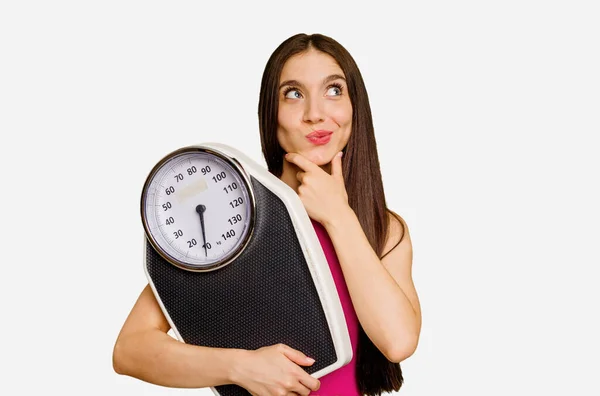 Young Caucasian Woman Holding Scale Isolated Looking Sideways Doubtful Skeptical — Stock Photo, Image