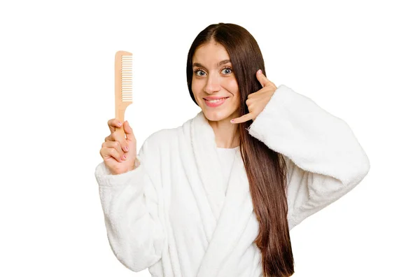 Young Caucasian Woman Holding Hair Comb Isolated Showing Mobile Phone — Stock Photo, Image