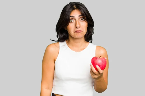 Young Indian Woman Holding Apple Healthy Lifestyle Isolated Shrugs Shoulders — Stock Photo, Image