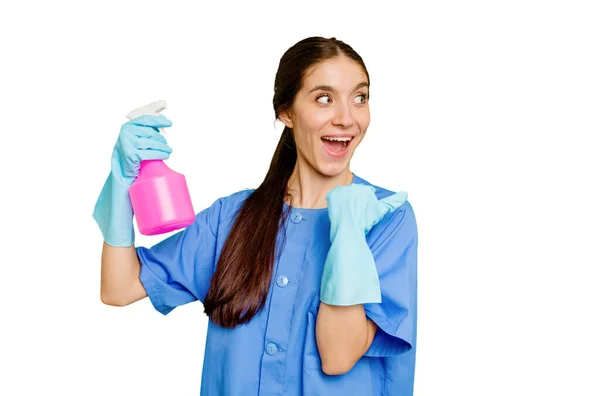 Young Cleaner Caucasian Woman Isolated Points Thumb Finger Away Laughing — Stock Photo, Image