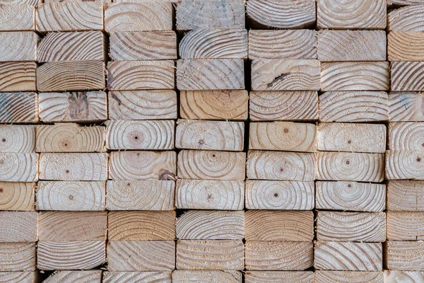 Photograph of the end profile of a stack of 2 x 4\'s in a lumber yard featuring the wood grain