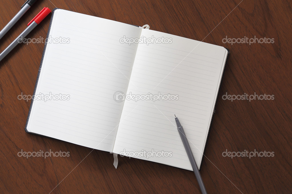 Notebook and pen on wood background