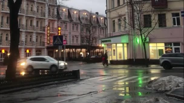 一个早冬的街道上 天气多风 沥青路面湿透 车辆在街上行驶 建筑物的灯火通明 — 图库视频影像