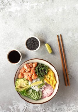 Pilav, mango, avokado, yosun, turp ve salatalıklı somon kabı. Sağlıklı fast food konsepti. Vejetaryen yemeği ya da akşam yemeği. Dikey yönelim, afiş. 