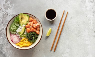 Pirinç, mango, avokado, yosun, turp ve salatalık ile somon kabı.. 