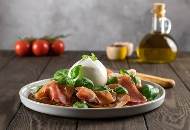 İtalyan Prosciutto peynirli, taze fesleğenli, domatesli ve zeytinyağlı. Sığ alan derinliği.