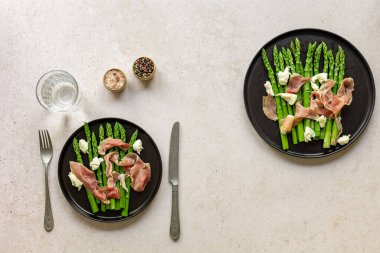 Mozzarella peyniri ve jambonlu yeşil kuşkonmaz. Mevsimlik lezzetli yemekler. İki tabağın üst görüntüsü, keto diyet öğle yemeği veya akşam yemeği..