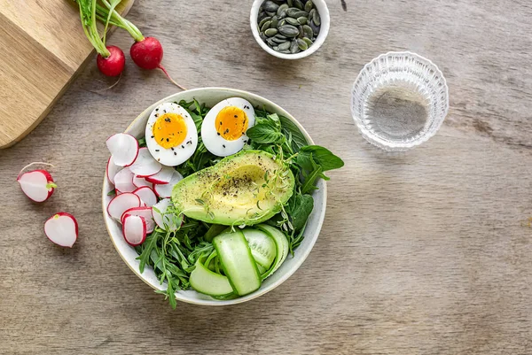Yaz sağlıklı yemekleri. Yumurtalı yeşil keto salatası, avokado, turp ve salatalık. Metin veya tarif için boşluk kopyala.