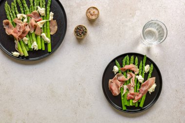 Mozzarella peyniri ve jambonlu yeşil kuşkonmaz. Mevsimlik lezzetli yemekler. İki tabağın üst görüntüsü, keto diyet öğle yemeği veya akşam yemeği..