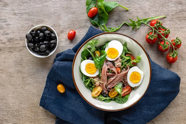 Nicoise Fransız salatası konserve ton balığı, ançüez, haşlanmış yumurta, domates ve siyah zeytin. Yaz için lezzetli bir yemek, akşam yemeği, keto diyeti.. 