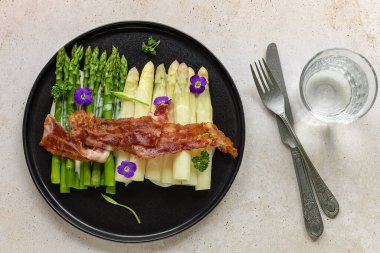 Kızarmış pastırmalı yeşil ve beyaz kuşkonmaz. Harika mevsimlik yemekler, Keto diyeti yemeği ya da öğle yemeği için kolay yemek..