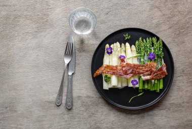 Kızarmış pastırmalı yeşil ve beyaz kuşkonmaz. Harika mevsimlik yemekler, Keto diyeti yemeği ya da öğle yemeği için kolay yemek..