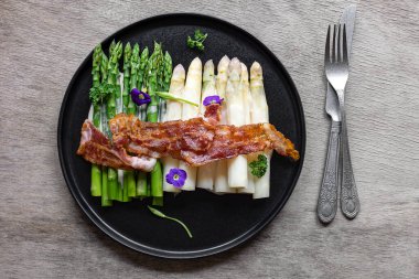 Kızarmış pastırmalı yeşil ve beyaz kuşkonmaz. Harika mevsimlik yemekler, Keto diyeti yemeği ya da öğle yemeği için kolay yemek..