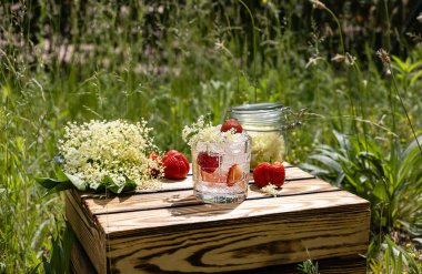 Yaz limonatası mürver çiçeği likörü ve çilekten yapılır. Güneşli bahçede serinletici soğuk bir içecek.. 