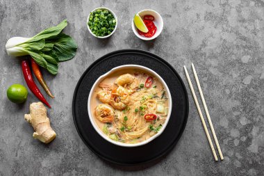 Bir kase körili laksa, Güneydoğu Asya 'da karides, bok choy, limon, zencefil ve biberli baharatlı cam şehriye yemeği. Latksa 'nın birçok çeşidi zengin ve baharatlı hindistan cevizi çorbasıyla hazırlanır..