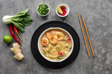 Bir kase körili laksa, Güneydoğu Asya 'da karides, bok choy, limon, zencefil ve biberli baharatlı cam şehriye yemeği. Latksa 'nın birçok çeşidi zengin ve baharatlı hindistan cevizi çorbasıyla hazırlanır..