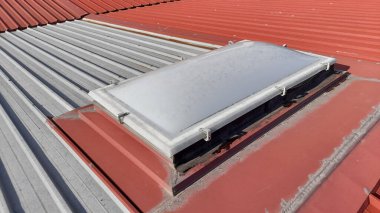 Eski çatı penceresi izole edilmiş bir sanayi binasının çatısında.