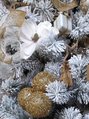 Toplar ve sanatsal dekorasyonlarla süslenmiş Noel ağacı