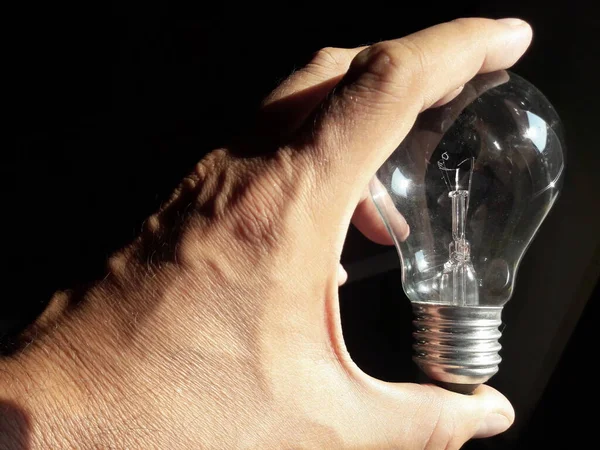 Halogen light bulb in the hands of a man