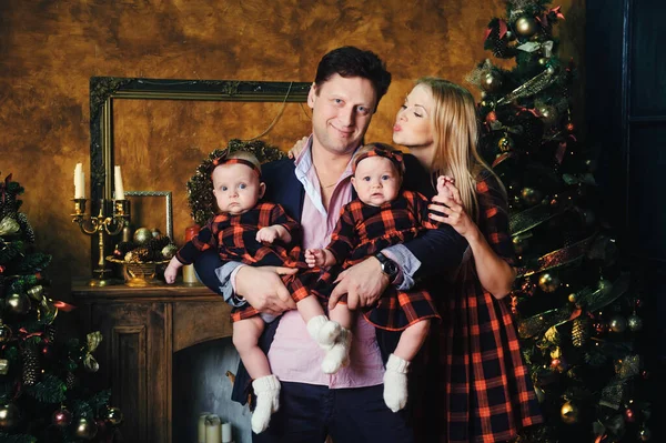 Noel ağacının yanındaki şöminenin yanında çocukları olan mutlu, büyük bir aile..