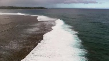 Dalgalar Hint Okyanusu 'ndaki Mauritius adasındaki mercan kayalıklarına çarpar.