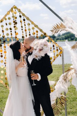 Düğün sırasında düğün kemerinin yanında mutlu bir çift..