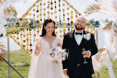 Düğün sırasında düğün kemerinin yanında mutlu bir çift..