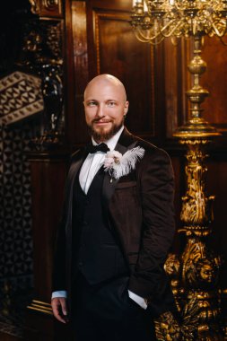 İç kısımda duran takım elbiseli ve papyonlu damadın portresi..