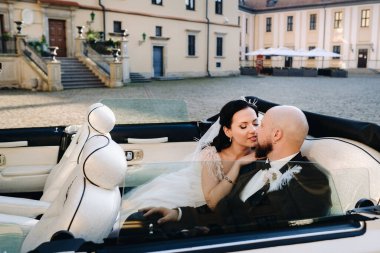 Şatonun avlusunda eski bir arabada zarif bir çift..