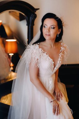 Gelinin portresi. Gelinin gelinliği. Evin içinde, aynanın yanında..