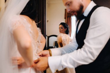 Gelinin sabahı. Damat geline gelinlik giydirir..