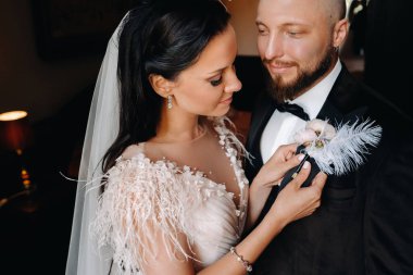 Gelin damadı evin içinde bir yaka çiçeğiyle giydirir..