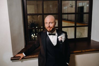 İç kısımda duran takım elbiseli ve papyonlu damadın portresi..