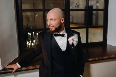 İç kısımda duran takım elbiseli ve papyonlu damadın portresi..