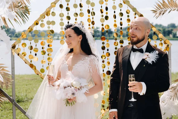 Düğün sırasında düğün kemerinin yanında mutlu bir çift..