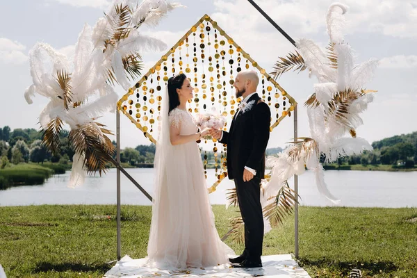 Düğün töreninde kemerin yanında mutlu bir çift var..