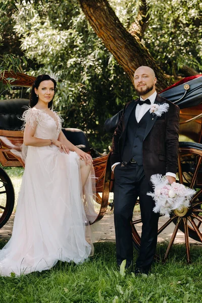 Gelin ve damadın bir çifti arabanın yanında dikiliyorlar..