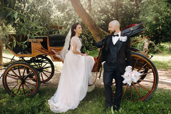 Gelin ve damadın bir çifti arabanın yanında dikiliyorlar..