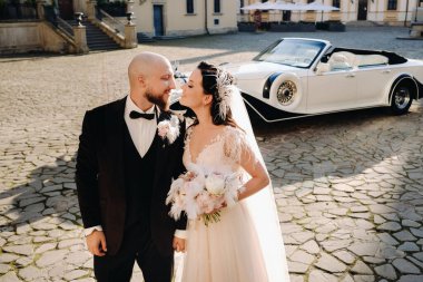 Şatonun avlusunda, eski bir arabanın yanında zarif bir çift..