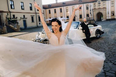 Şatonun avlusunda, eski bir arabanın yanında zarif bir çift..