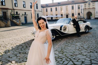 Şatonun avlusunda, eski bir arabanın yanında zarif bir çift..