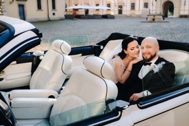 Şatonun avlusunda eski bir arabada zarif bir çift..